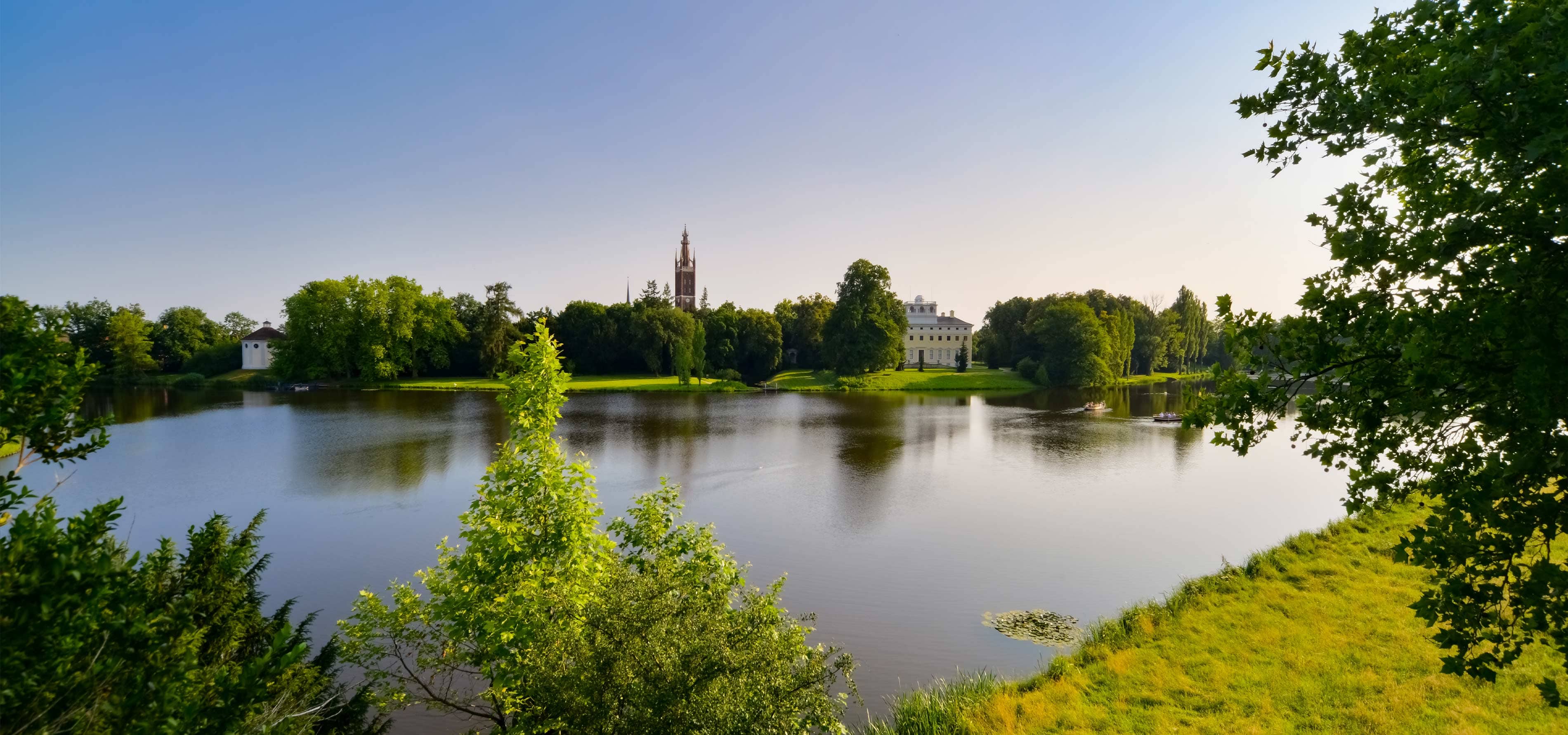 Foto vom Gartenreich Dessau-Wörlitz, einem beliebten Ausflugsziel mit imposanten Gebäuden und einem großen See in der Mitte